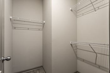 A walk in closet with two white closets and a door